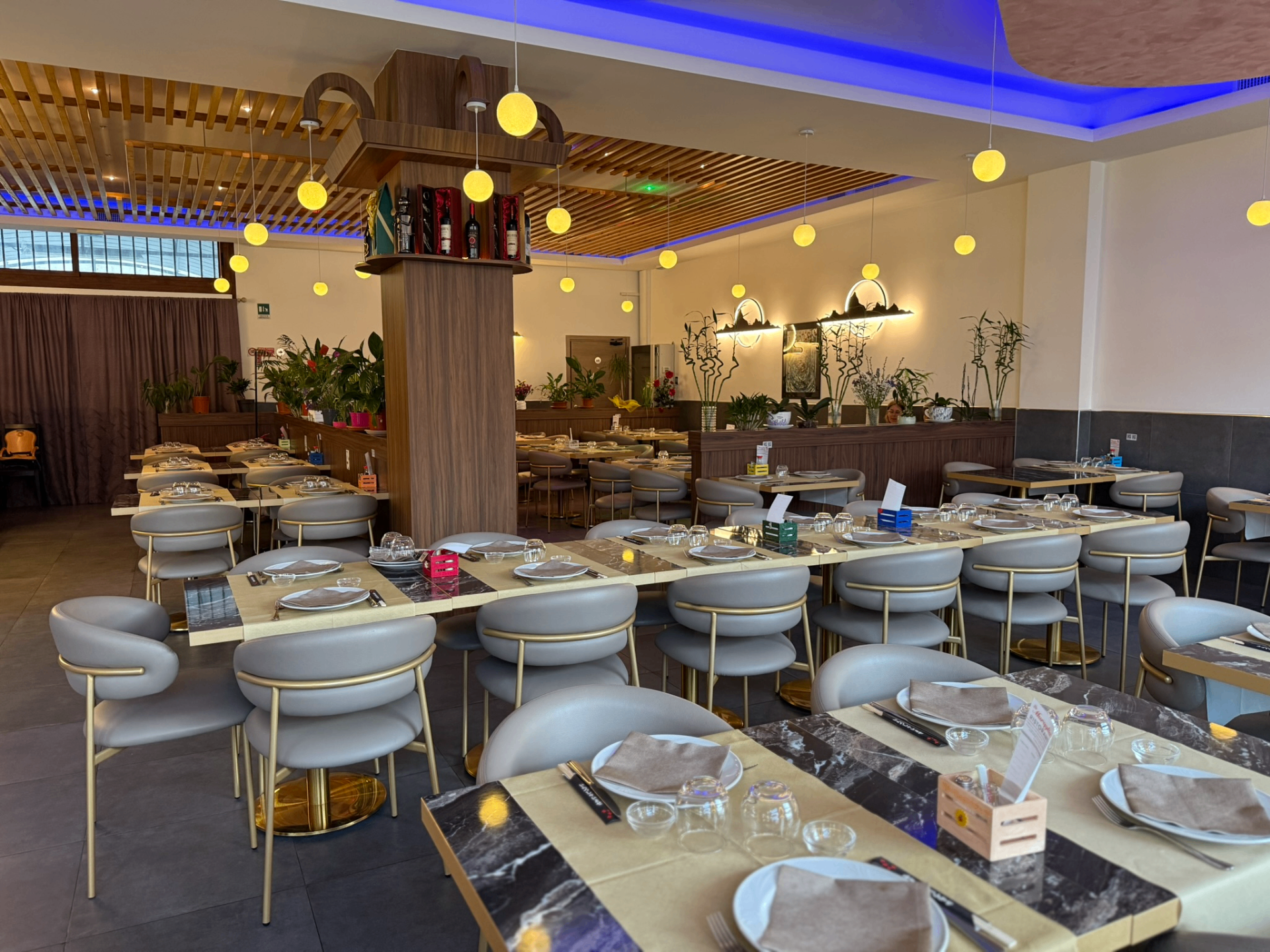Sala interna del ristorante La Muraglia con tavoli apparecchiati e luci sospese